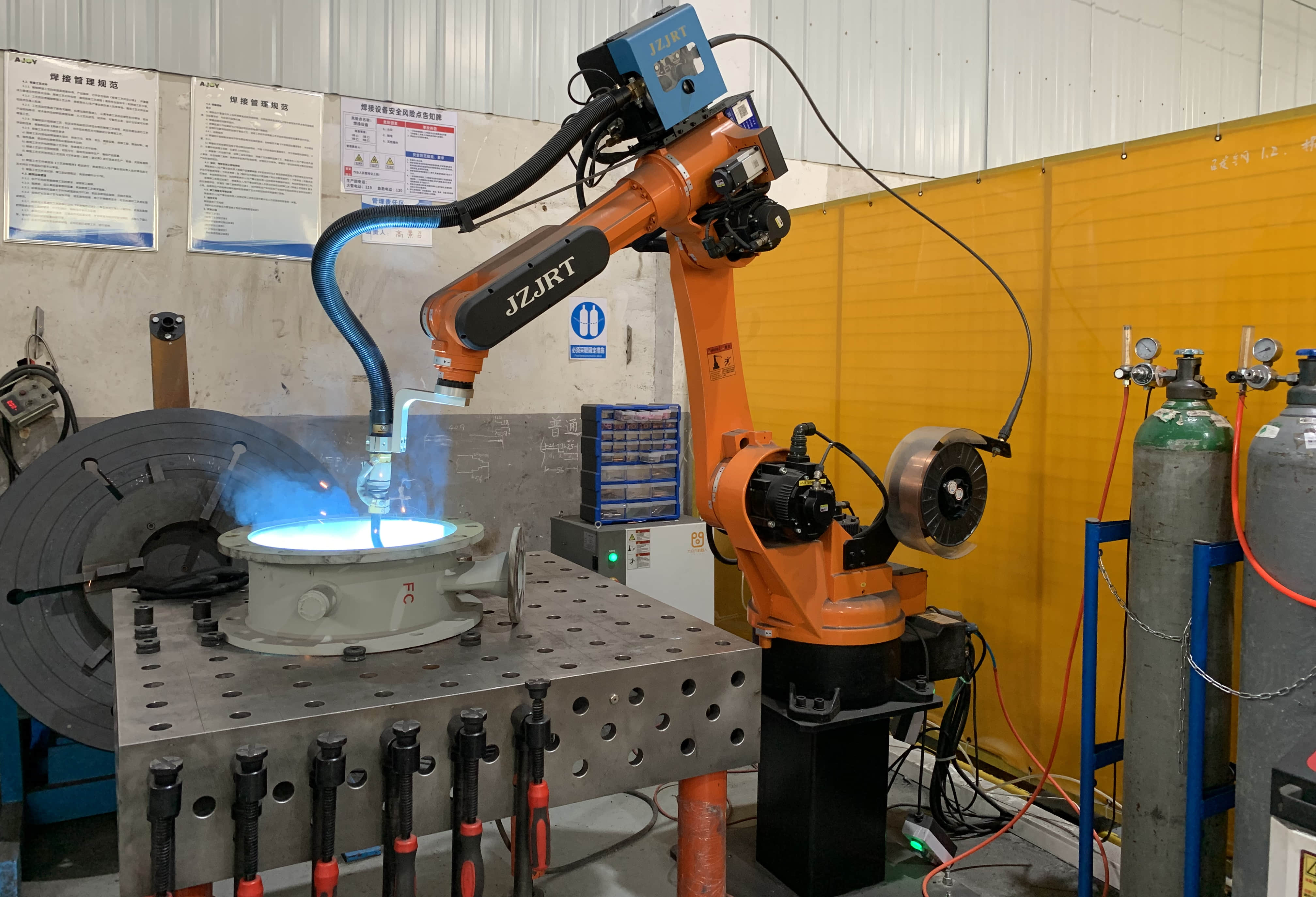 A six-axis robot welds industrial flue dampers in the FORENSERVTEK workshop.