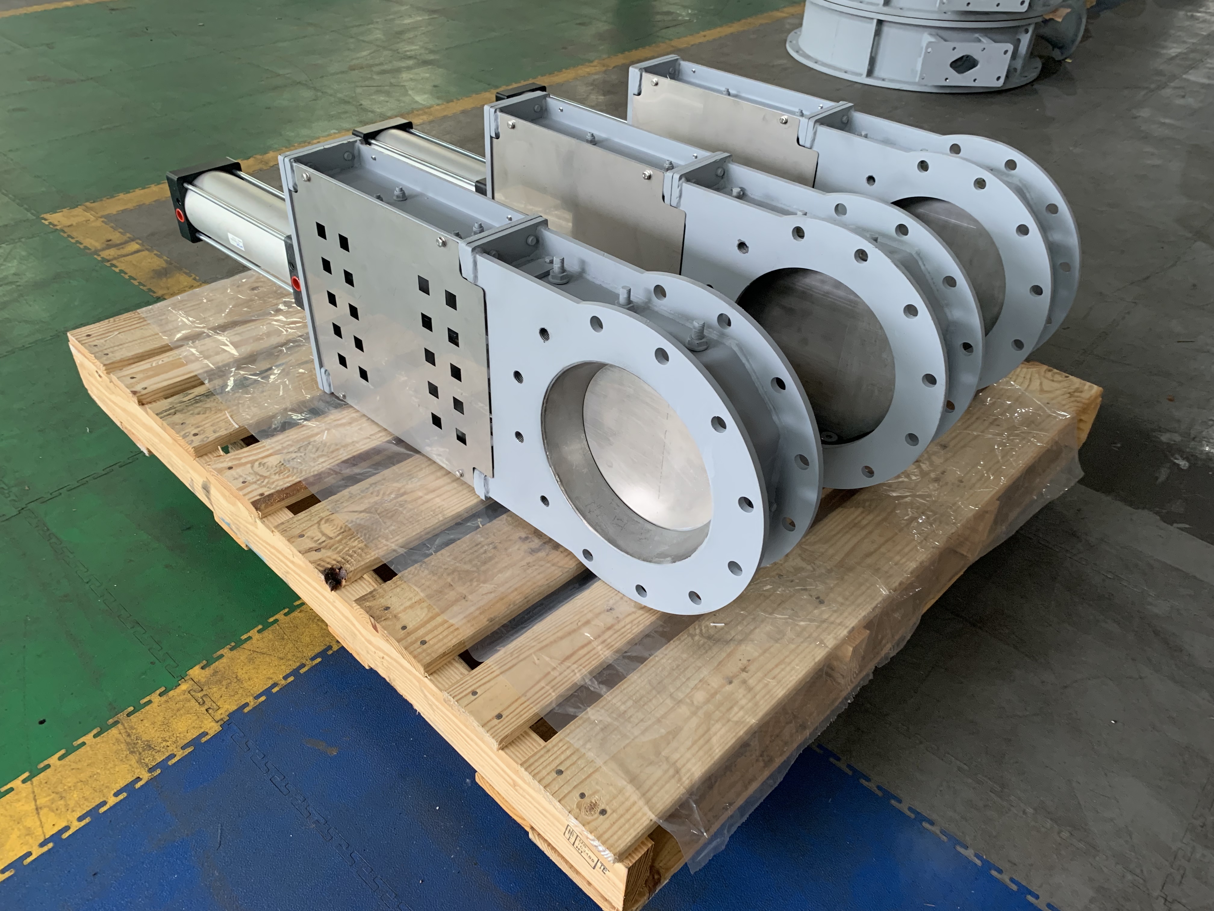 Three completed round flange pneumatic guillotine isolation damper are placed in the workshop equipped with pneumatic actuators used for flue gas isolation in the biomass power industry