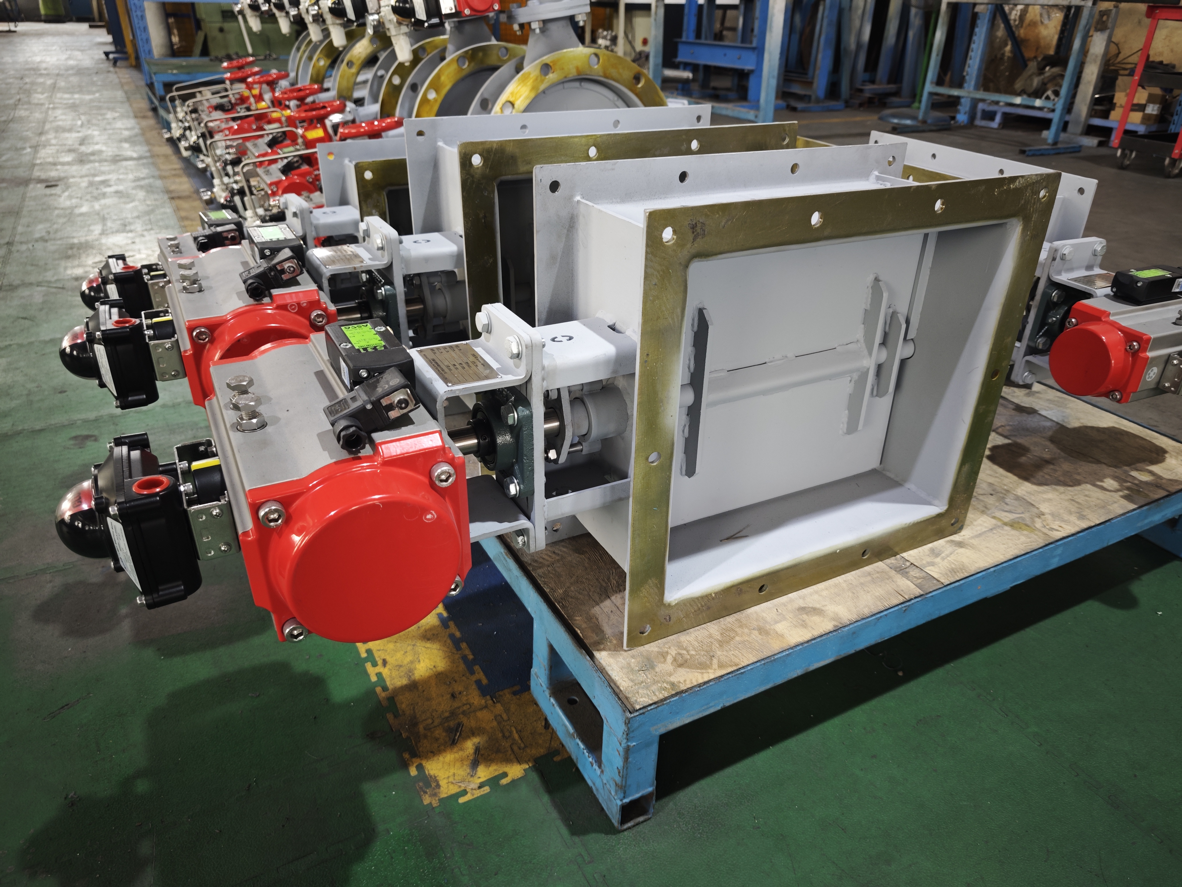 Mass produced rectangular pneumatic louver damper are placed on workshop pallets equipped with pneumatic actuators and limit switches used to cut off exhaust gas in RTO units