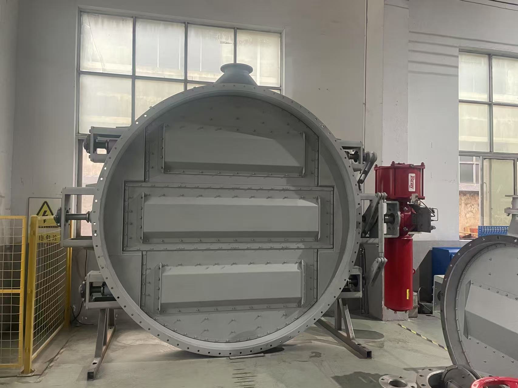 A huge three stem pneumatic air sealing flue isolation butterfly damper in the workshop equipped with a pneumatic actuator used for flue gas isolation in the dust removal system of waste heat boilers in the cement