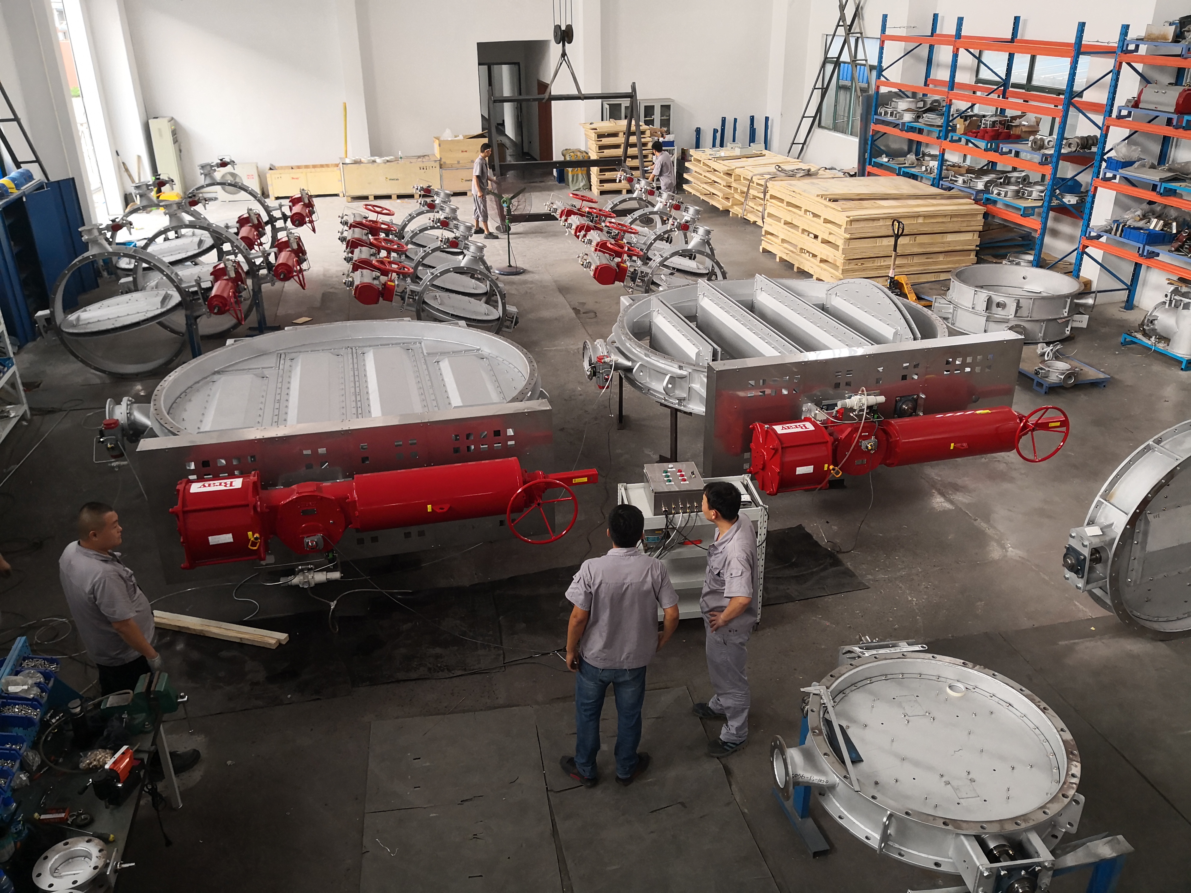 Two pneumatic air sealing isolation butterfly dampers in the factory workshop are linked for testing equipped with pneumatic actuators used for high temperature flue gas bypass isolation in a steel plants carbon dioxide